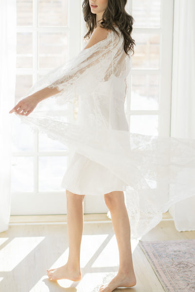 a bride twirls wearing by catalfo's white lace bridal robe