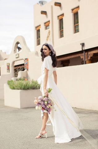 a bride walks in an elegant long white elopement wedding dress