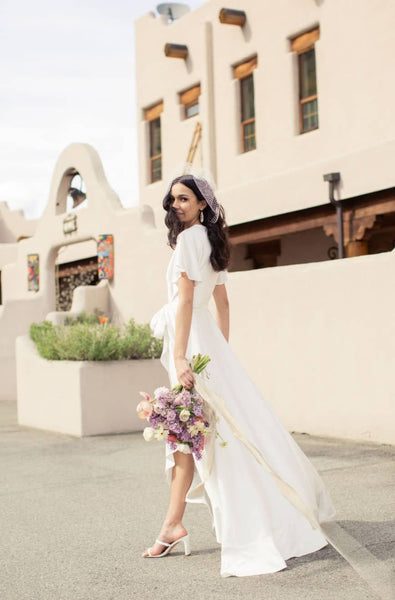 a bride walks in an elegant long white elopement wedding dress