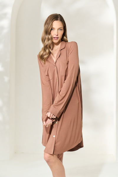 Woman wearing a knee length button-up brown modal boyfriend shirt with long sleeves