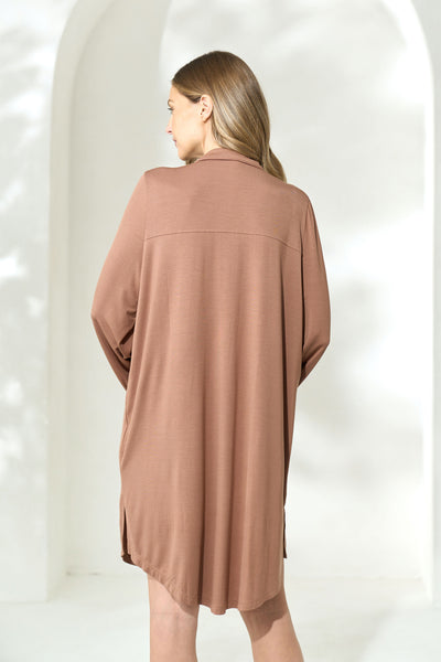 Back view of woman wearing knee length brown modal boyfriend shirt. 