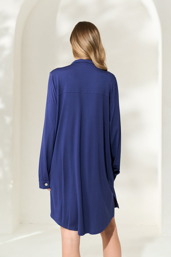 Back view of woman wearing knee-length navy modal boyfriend shirt with long sleeves