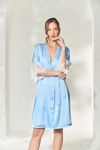 Woman posing seductively in her powder blue robe with lace sleeves.