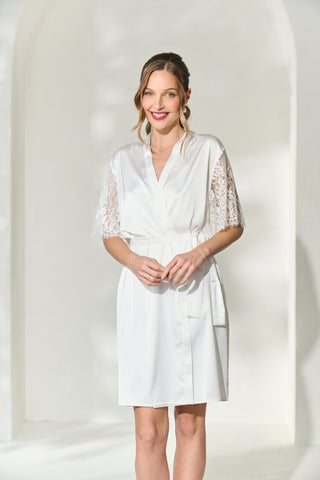 Smiling woman wearing white bridal robe with lace sleeves