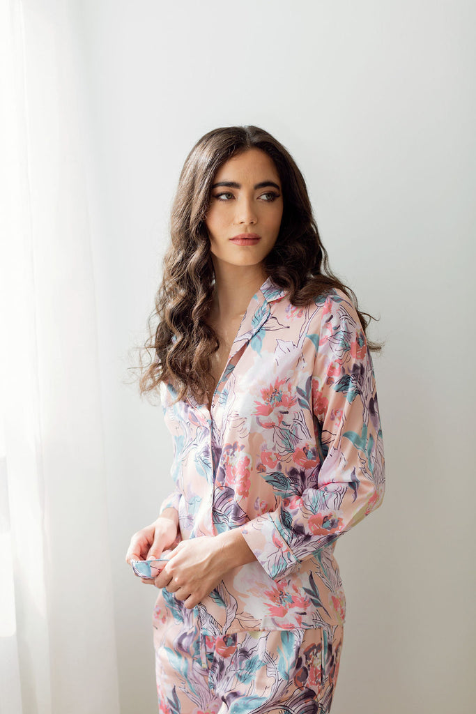 Woman wearing light pink floral pajamas looking to the left. 
