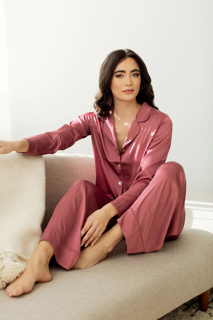 Woman sitting on couch wearing strawberry rose silky pajamas