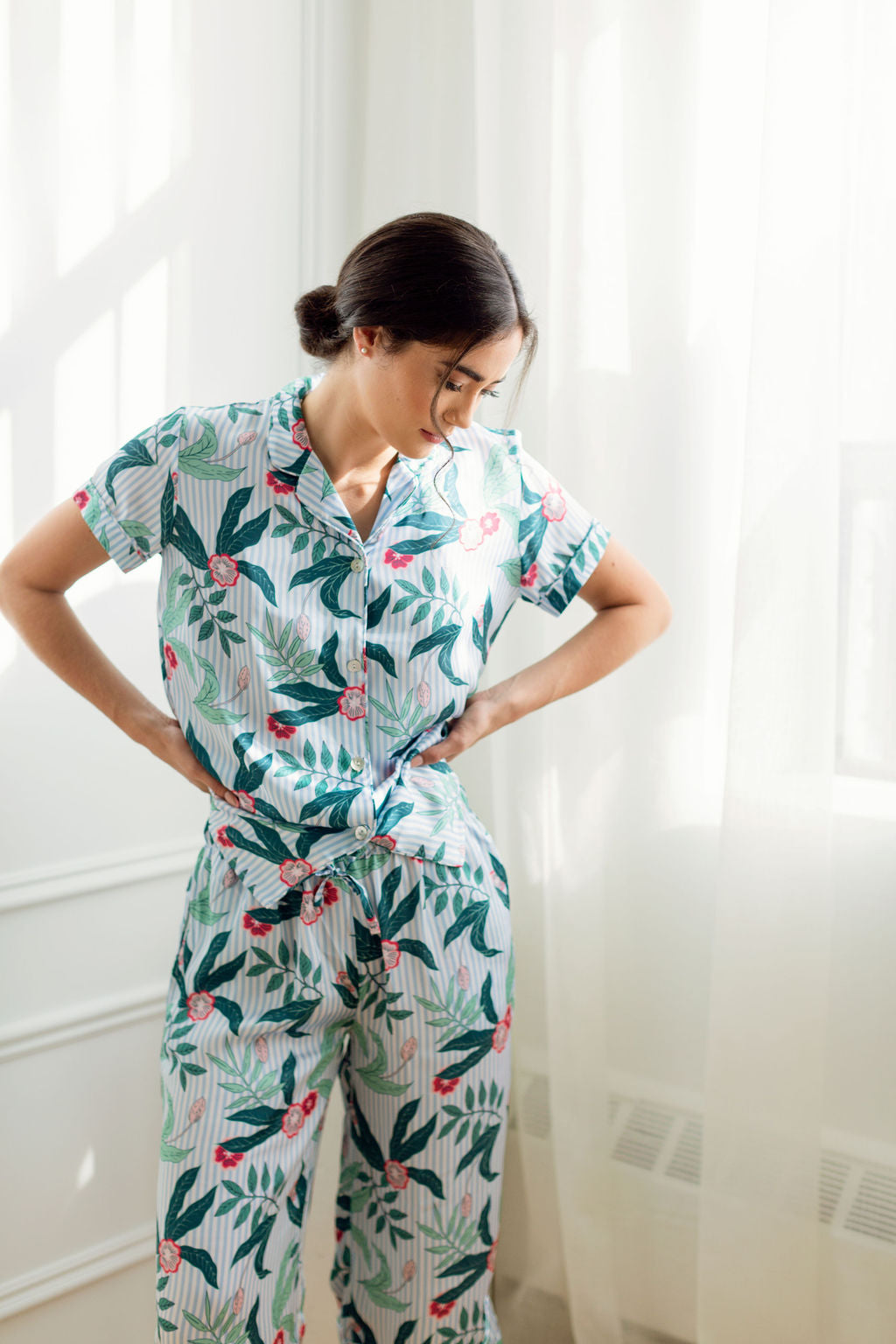 Woman looking at ground pensively wearing floral print pajamas