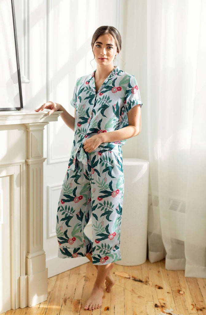 Woman standing by fireplace wearing short sleeve floral pajamas