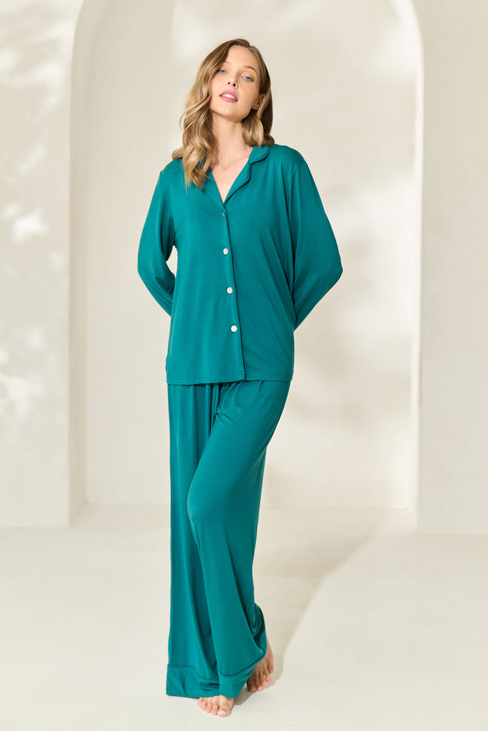 Woman posing with arms behind her back wearing button-up long sleeve juniper green modal PJ set