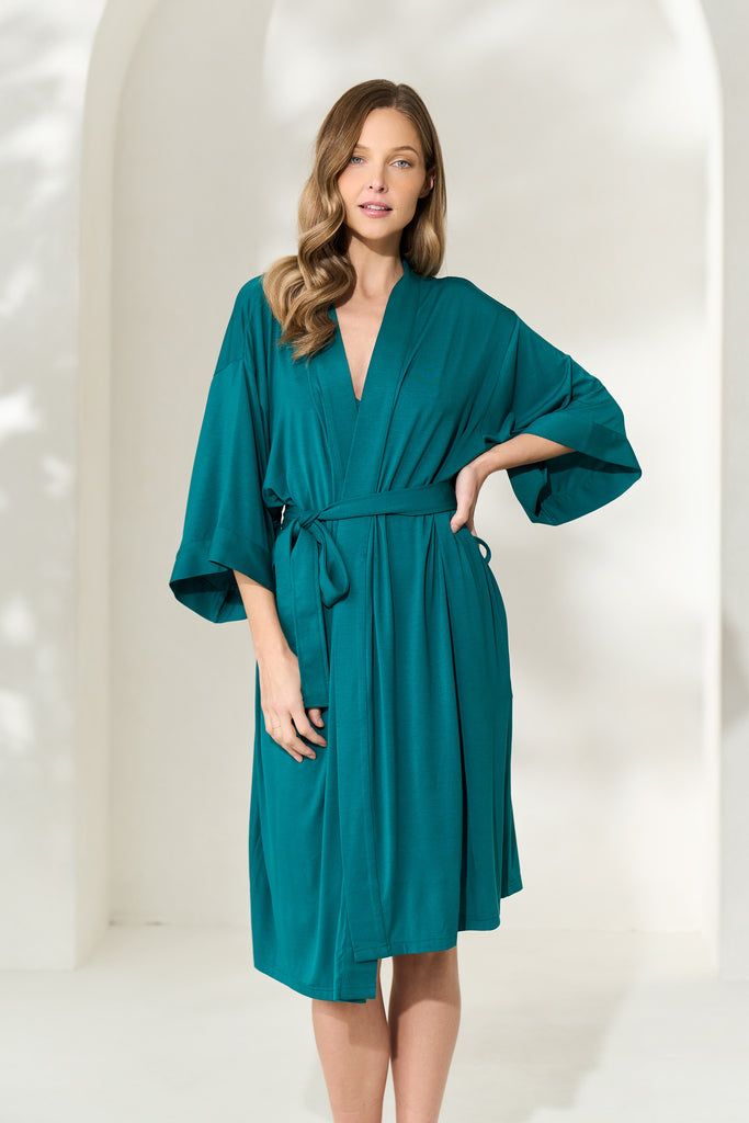 Woman posing with hand on waist wearing an elegantly draping juniper green modal robe
