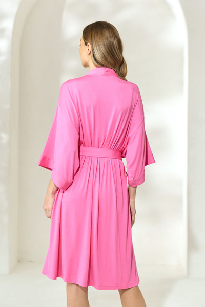 Back view of woman wearing sorbet pink knee-length modal robe with waist tie