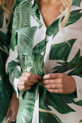 Woman doing up button on palm print boyfriend shirt