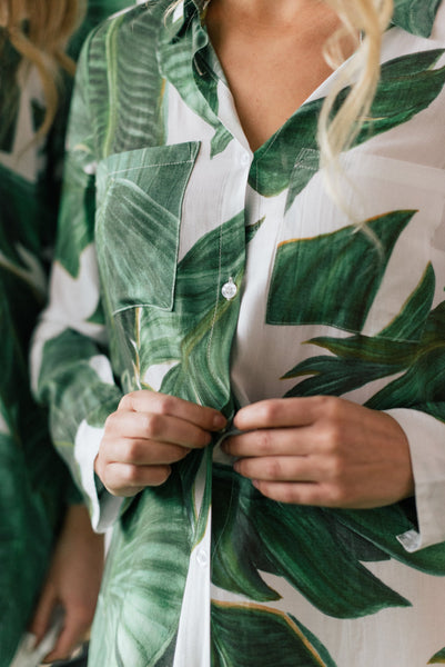 Woman doing up button on palm print boyfriend shirt