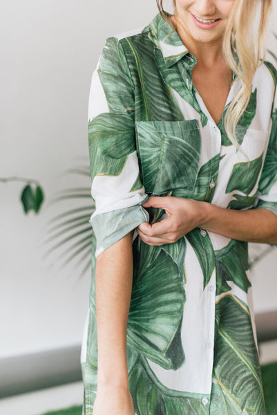 Women rolling up sleeve of palm print boyfriend shirt