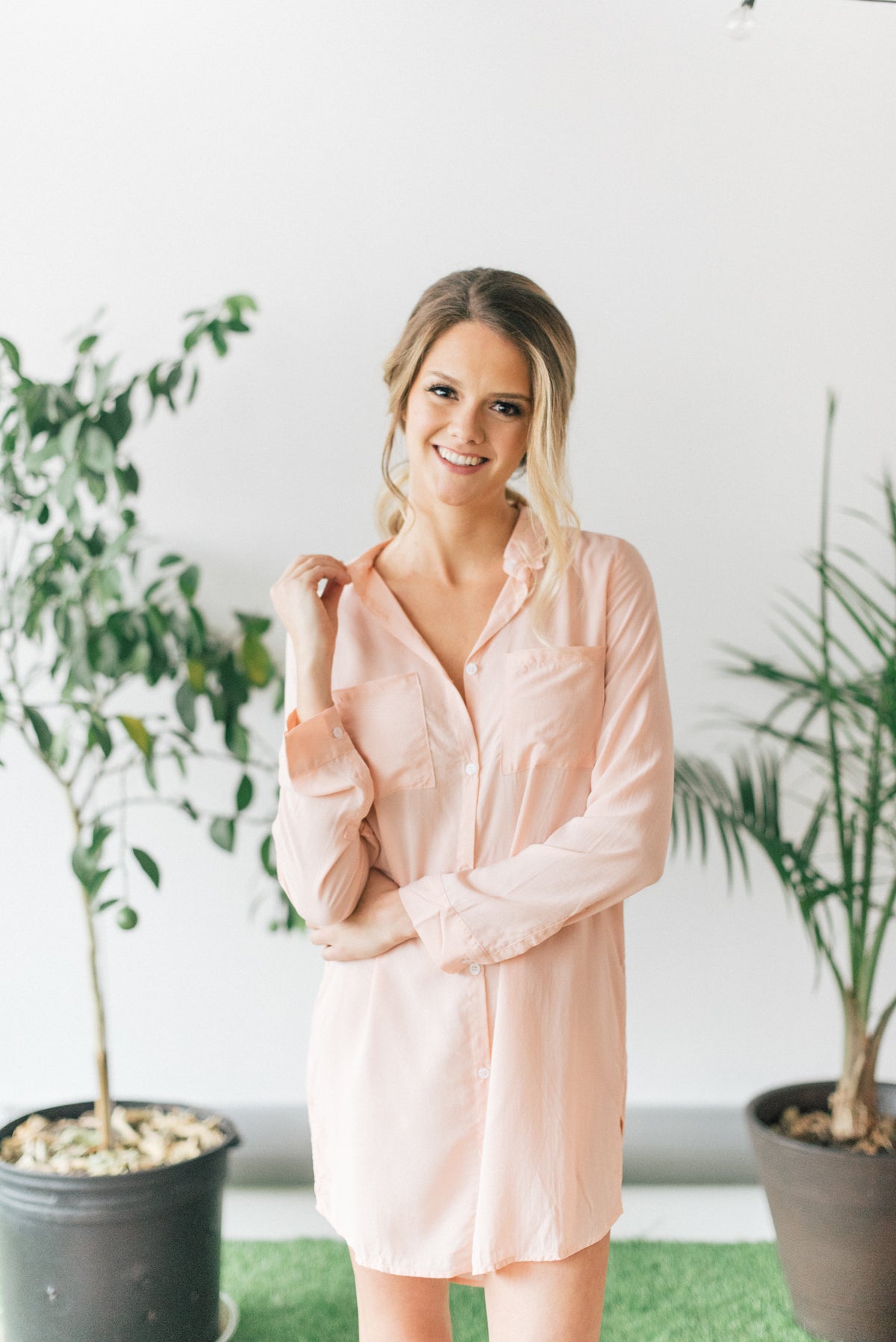 Woman wearing peach colored knee-length boyfriend shirt