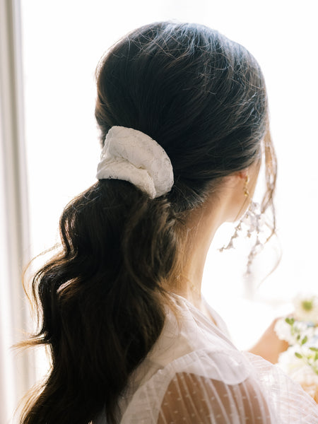 low ponytail hairstyle for brides with By Catalfo lace scrunchie