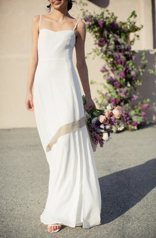 a bride walking wearing a flowy white minimalist wedding gown 
