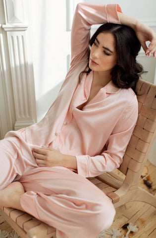 a model lounging casually in silky blush pj's from By Catalfo
