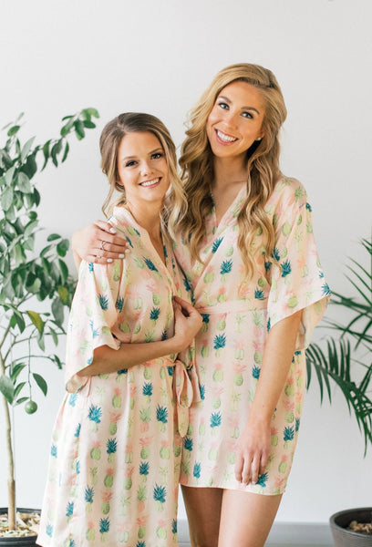 bridesmaids getting ready in pineapple print bridal robes from by catalfo