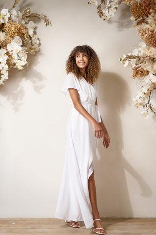 side view of a model wearing elegant wedding wrap dress with flutter sleeves