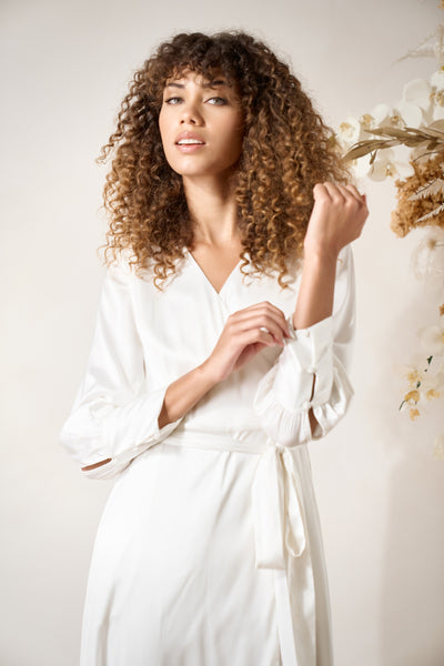 a model wears elegant white wrap dress with long sleeves, for micro weddings and elopements
